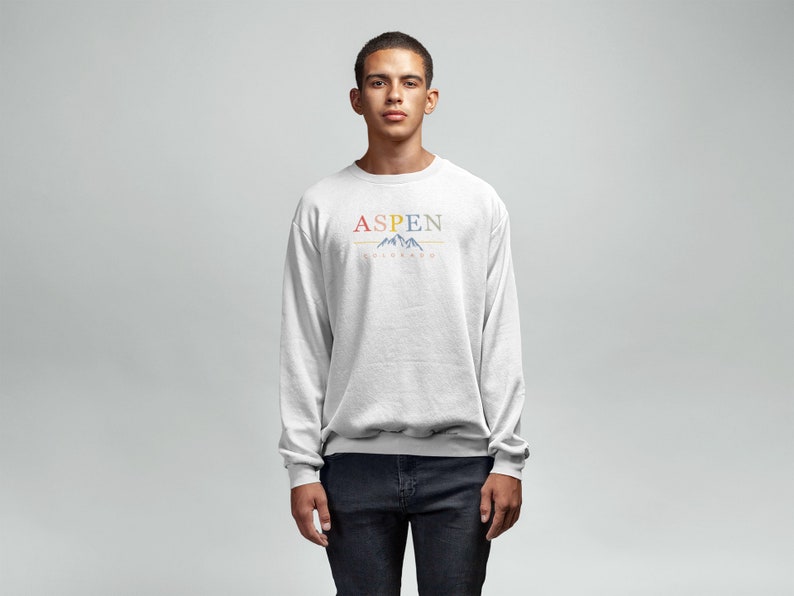 May include: A light gray sweatshirt with a colorful graphic print that says "ASPEN" with a mountain range design underneath.