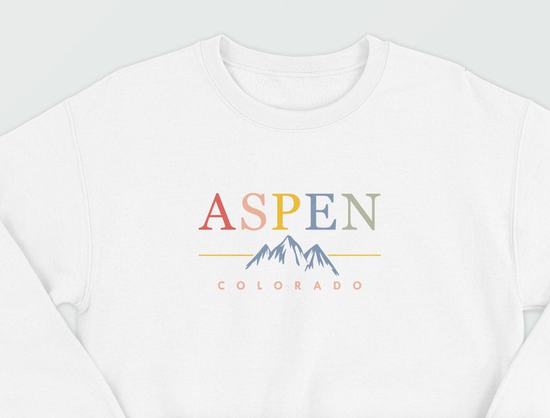 May include: White sweatshirt with a colorful graphic design that says "ASPEN COLORADO" with a stylized mountain range in blue.