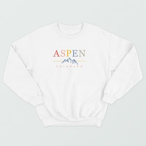 May include: White sweatshirt with a graphic design of the word "ASPEN" in colorful letters, a mountain range, and the text "COLORADO" underneath.