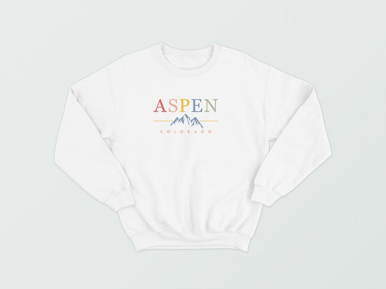 May include: White sweatshirt with a graphic design of the word "ASPEN" in colorful letters, a mountain range, and the text "COLORADO" underneath.