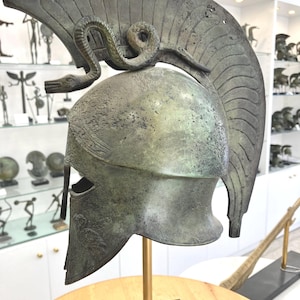 Bronze Spartan Helmet mid size two snakes the symbol of good health.  Owl on cheek plate symbol of wisdom Free marble base. Height: 42 cm