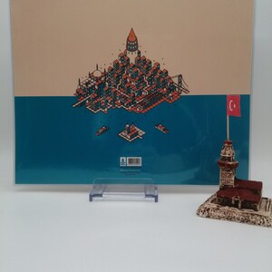 May include: A colorful illustration of the Istanbul skyline with the Galata Tower, the Hagia Sophia, and the Bosphorus Bridge. The illustration is printed on a white card with a blue and beige background. A small Turkish flag is in the corner of the card.
