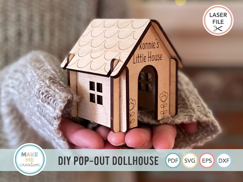 May include: A wooden dollhouse kit with a pop-out design. The dollhouse is light brown and has a roof with a scalloped edge. The dollhouse has a front door and a window. The text "Ronnie's Little House" is engraved on the front of the dollhouse.