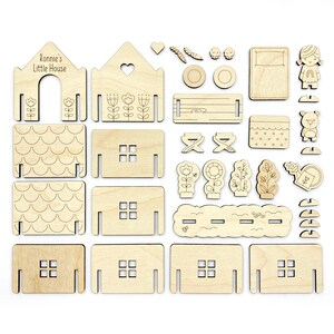 May include: A wooden craft kit for building a house with a personalized name, "Ronnie's Little House". The kit includes various pieces for the house, roof, windows, doors, and a garden with flowers, trees, a watering can, a fence, a beehive, a swing set, a pool, a bear, and a girl.