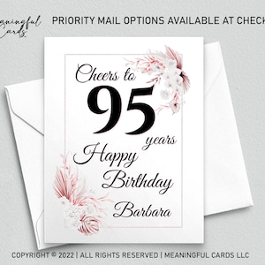 May include: A white card with a pink floral design and the text "Cheers to 95 years Happy Birthday Barbara".