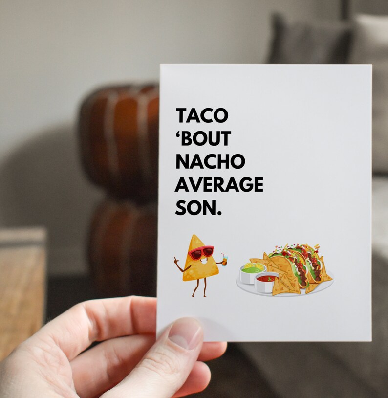 May include: A white greeting card with the text "TACO 'BOUT NACHO AVERAGE SON." features a cartoon nacho chip wearing sunglasses and holding a drink. A plate of tacos and nachos is also shown.