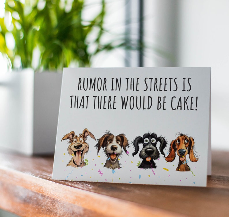 May include: A white card with the text "RUMOR IN THE STREETS IS THAT THERE WOULD BE CAKE!" and four cartoon dogs with different expressions. The dogs are wearing party hats and there are confetti and streamers around them.