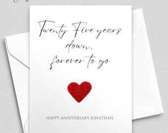 May include: A white card with black text that reads "Twenty Five years down, forever to go."  A red felt heart is below the text. The text "HAPPY ANNIVERSARY JONATHAN" is below the heart. The text "COPYRIGHT © 2022 | ALL RIGHTS RESERVED | MEANINGFUL CARDS LLC" is at the bottom of the card.
