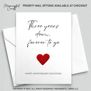 May include: A white card with black calligraphy that reads "Three years down, forever to go." A red felt heart is centered below the text. The card reads "Happy Anniversary Jonathan" at the bottom.