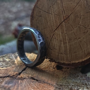 A hand-forged black steel ring with polished edges.