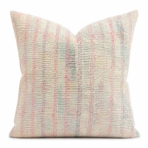 May include: A square throw pillow featuring a cream-colored base with a textured, quilted surface. The fabric is adorned with vertical stripes in faded shades of pink, blue, and yellow, created by visible running stitches across the entire front.