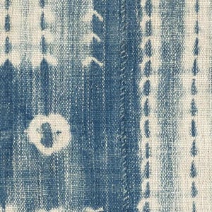 Puede incluir: Un tejido con un patr&oacute;n de te&ntilde;ido anudado en azul profundo y blanco roto. El dise&ntilde;o consiste en rayas verticales, motivos circulares y formas rectangulares creadas mediante una t&eacute;cnica de te&ntilde;ido por reserva sobre una tela de tejido grueso.