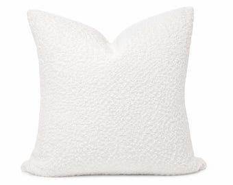 May include: A square scatter cushion featuring a bright white, textured, nubby fabric surface. The cushion has a distinct, plush, and looped appearance with a soft, voluminous shape that creates a clean, uniform look across the entire front face.