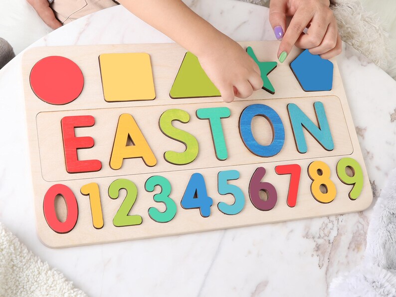 May include: Wooden puzzle board with colorful shapes, letters spelling "EASTON", and numbers 0-9. The shapes include a red circle, yellow square, green triangle, green star, and blue pentagon. A fun educational toy.