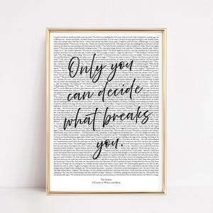 May include: A framed print with a gold border. The print features a background of small text with the words "Only you can decide what breaks you" in a handwritten style. The author's name and book title are at the bottom.