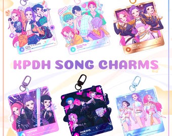 May include: A collection of KPDH song charms featuring colorful illustrations of anime-style characters. Each charm has a different design, with text such as "HOW IT'S DONE", "Soda Pop", "TAKE DOWN", "YOUR IDOL", "GOLDEN", and "WHAT IT SOUNDS LIKE". Each charm includes a silver or gold-colored clasp.