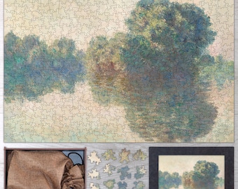 May include: A wooden jigsaw puzzle of a painting depicting a river scene with trees and reflections in the water. The puzzle is assembled and displayed on a wooden surface. A bag of puzzle pieces and a framed image of the completed puzzle are also shown.