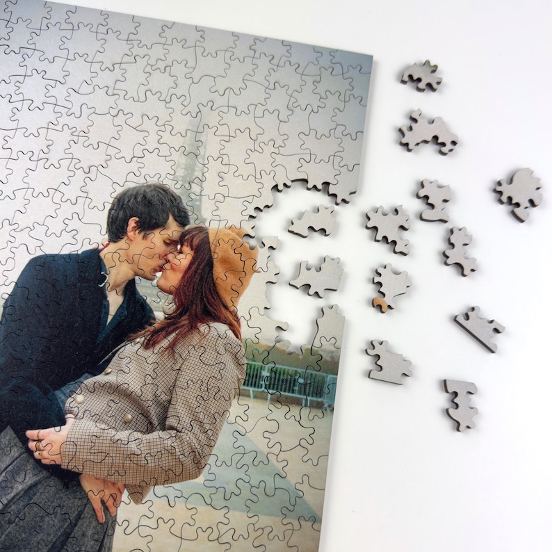 Custom wooden photo puzzle with scattered puzzle pieces, personalized jigsaw puzzle made from a couple photo printed on a premium wooden puzzle.