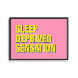 May include: A framed pink poster with the text "SLEEP DEPRIVED SENSATION" in yellow letters.