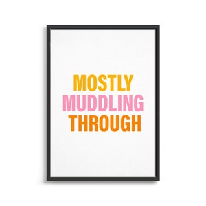May include: A framed print with the text "MOSTLY MUDDLING THROUGH" in orange, pink, and yellow lettering on a white background.