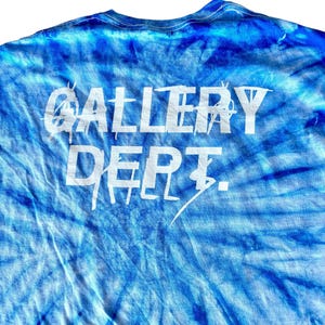 May include: A blue tie-dye t-shirt with the words "GALLERY DEPT." printed in white on the back.