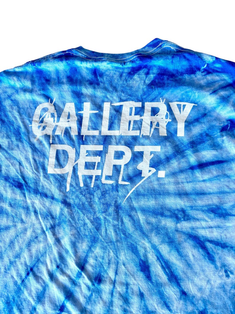 May include: A blue tie-dye t-shirt with the words "GALLERY DEPT." printed in white on the back.