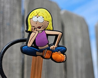 May include: A yellow, orange, blue, and purple cartoon character with blonde hair is sitting on a brown straw with a black ring around it. The character is wearing a purple tank top and blue jeans. The character is sitting with their legs crossed and their hands on their knees. The character is looking to the right.