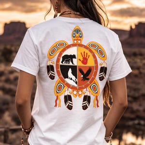 Puede incluir: Una taza de cerámica blanca con un asa negra y el texto "But First, Coffee" en negrita negra. La taza se encuentra sobre un fondo neutro, resaltando su diseño sencillo.