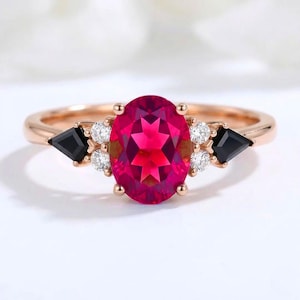 Anillo de compromiso ovalado de tres piedras con rubí creado en laboratorio, oro rosa, ónix negro y moissanita.