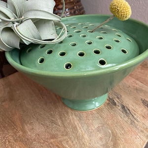 May include: A set of three ceramic mugs with a speckled, matte finish in cream, light grey, and dark grey. Each mug has a simple, minimalist design and a rounded handle.