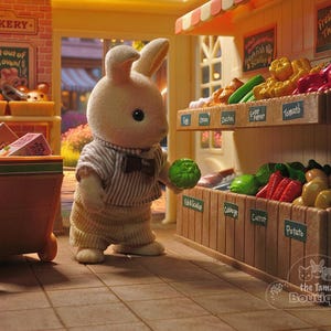 May include: A miniature toy scene of a bunny in a striped shirt and bow tie holding a green vegetable in a toy grocery store. The store has shelves of produce, including tomatoes, potatoes, and carrots. A bakery is in the background.