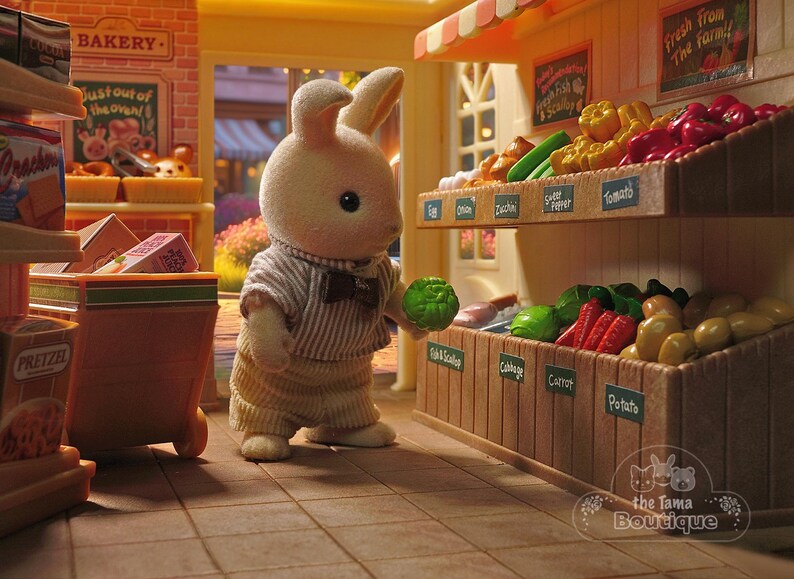 May include: A miniature toy scene of a bunny in a striped shirt and bow tie holding a green vegetable in a toy grocery store. The store has shelves of produce, including tomatoes, potatoes, and carrots. A bakery is in the background.