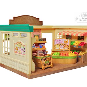 May include: A miniature toy grocery store with a beige exterior, green trim, and a brown roof. The store features shelves stocked with miniature food items, a shopping cart, and displays of fruits and vegetables. The sign reads "Fresh Fruit".