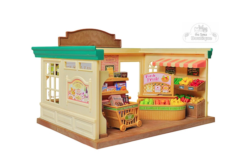 May include: A miniature toy grocery store with a beige exterior, green trim, and a brown roof. The store features shelves stocked with miniature food items, a shopping cart, and displays of fruits and vegetables. The sign reads "Fresh Fruit".