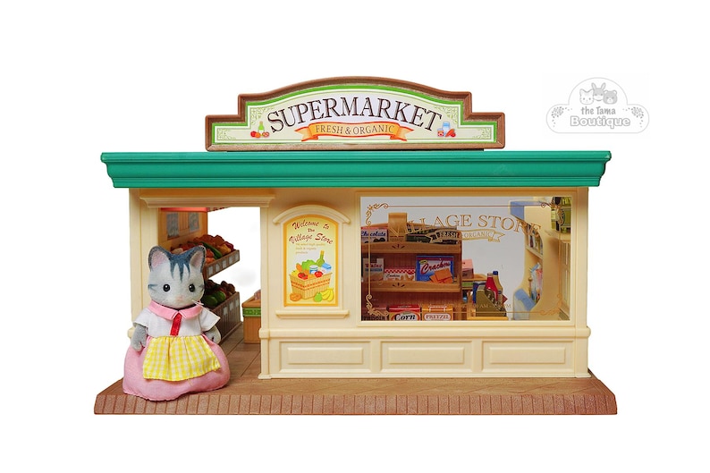 May include: A miniature toy supermarket with a green roof and a sign that reads "SUPERMARKET FRESH & ORGANIC". A gray cat figure in a pink dress and yellow apron stands in front of the store. The store has shelves with miniature food items.