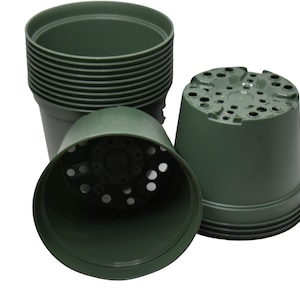 May include: A collection of dark green plastic plant pots. The pots are cylindrical with a slightly flared top and a series of drainage holes in the bottom. Some pots are stacked, while others are overturned, showcasing the interior.
