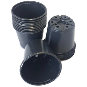 May include: A stack of black plastic plant pots with drainage holes. The pots are 4 inches in diameter.