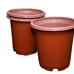 May include: Two brown plastic plant pots, one slightly larger than the other. Both pots have a smooth, rounded shape and a slightly flared lip.
