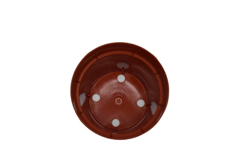 May include: A terracotta colored plastic plant pot with four drainage holes in the bottom.