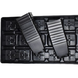 Puede incluir: Bandeja de siembra de plástico negro con múltiples celdas individuales. Dos insertos de celdas de plástico negro vacíos están encima de la bandeja.