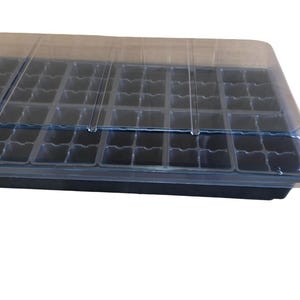 May include: A black plastic seed starting tray with a clear plastic dome lid. The tray has 72 individual cells for starting seeds.
