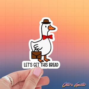 May include: A sticker featuring a cartoon goose wearing a brown hat and red bow tie, carrying a briefcase. The text "LET'S GET THIS BREAD" is below the goose. The background has a gradient of orange, pink, and blue.