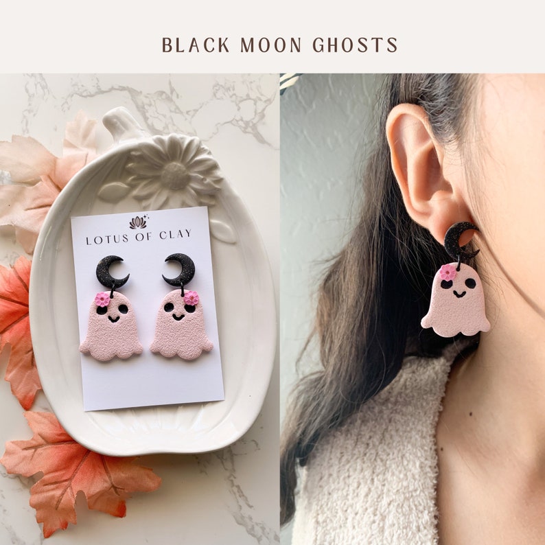 May include: Pink ghost earrings with black crescent moons and pink flowers. The earrings are on a white card with the text "LOTUS OF CLAY".