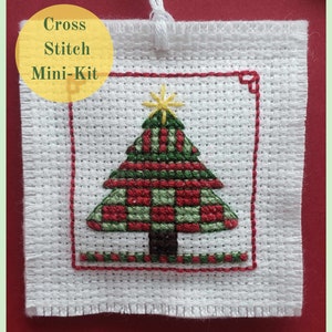 Peut inclure: Kit de point de croix miniature avec un sapin de Noël en plaid vert et rouge avec une étoile jaune au sommet. Le kit comprend un tissu Aida, du fil à broder et une aiguille.