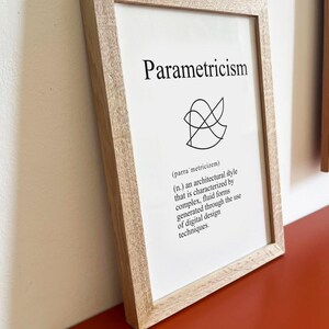 Könnte beinhalten: Ein gerahmter Druck mit dem Wort "Parametricism" in schwarzer Schrift. Darunter befindet sich ein abstraktes schwarzes Design und die Definition. Der Rahmen besteht aus hellem Holz.