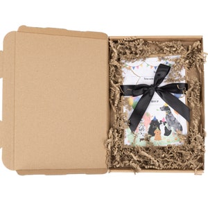 May include: A brown cardboard box with a black ribbon tied around a white card with a colorful illustration of dogs wearing party hats. The card says "You are invited to a Pawty!" and "Join P..."