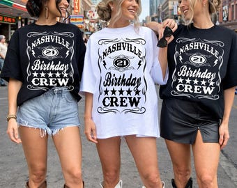 May include: Three t-shirts featuring the text Nashville 21 Birthday Crew with lightning bolts and stars. Two shirts are black with white text, and one shirt is white with black text. The designs include decorative flourishes and borders.