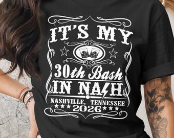 May include: Black t-shirt with white text that reads "IT'S MY 30th Bash IN NASHVILLE, TENNESSEE 2026". The design includes two glasses of whiskey and star accents. The shirt is a casual wear item.