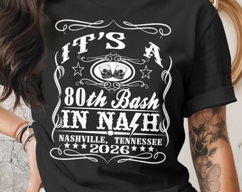 May include: Black t-shirt with white text that reads "IT'S A 80th Bash IN NASH" with "Nashville, Tennessee 2026" below. The design includes stars and images of two glasses with ice.