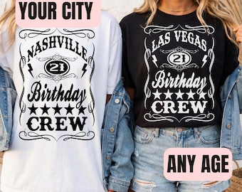 May include: Two t-shirts, one white and one black, with birthday-themed designs. The white shirt says "Nashville Birthday Crew" and the black shirt says "Las Vegas Birthday Crew". Both shirts feature a "21" graphic and star accents.